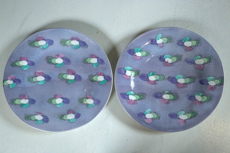 Pair of 1972 Lyn Evans abstract design pottery chargers in lavender, green, mauve and cream.