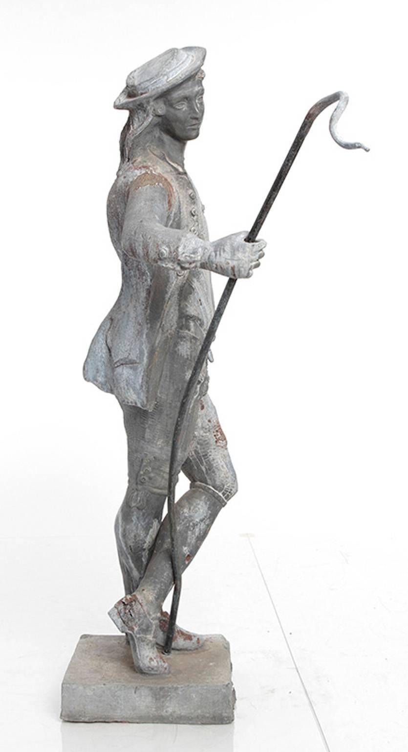 Pair of 19th century lead garden statues of a shepherd and a shepherdess. The shepherd holds a cane while his female counterpart holds a lamb. 

Dimensions:
Shepherdess W 18