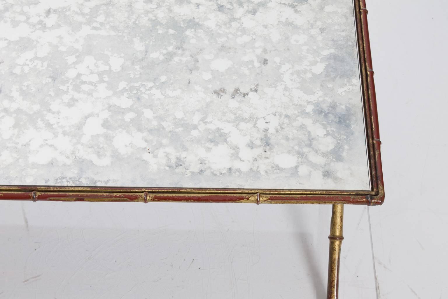 Low cocktail table with gilt details and a chinoiserie motif. Mercury glass top (not original).