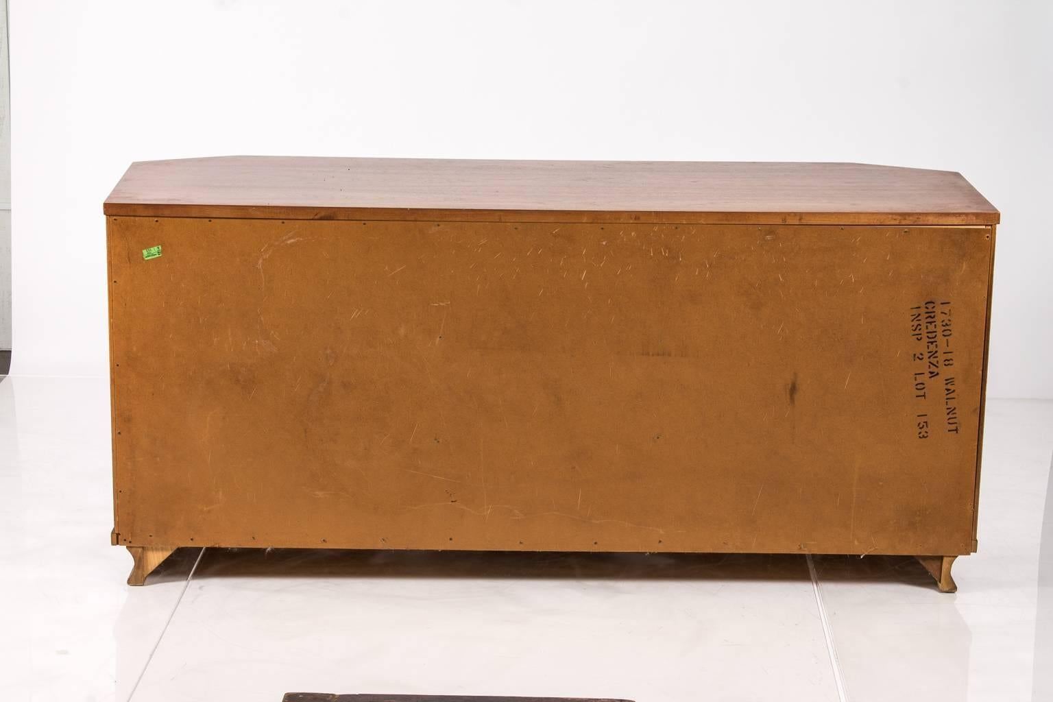 Large Mid-Century credenza. Carved in walnut and containing several shelves and drawers.