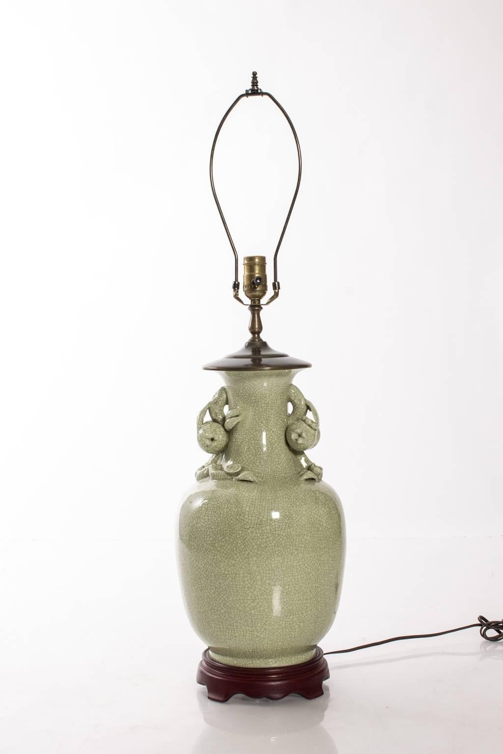 Ceramic celadon table lamp with decorative fruit adornments.