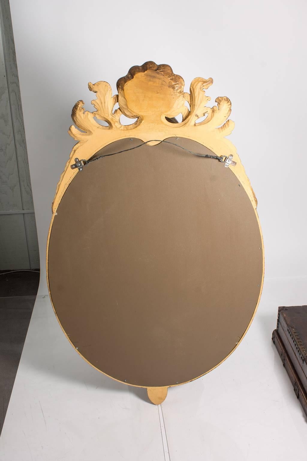 Large oval mirror in a gilt shell crest frame.