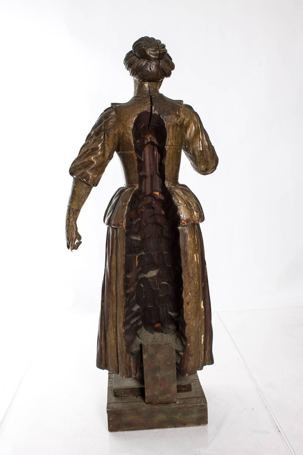 Carved lifesize Victorian figure of a maid. This piece was possibly an architectural element of a larger wooden structure (you can see on the back where the figure was attached), such as staircase.