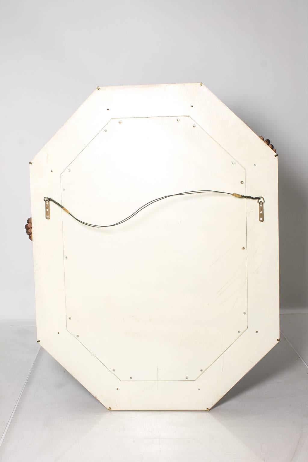 Octagonal wall mirror in the Karl Springer style with brass details.