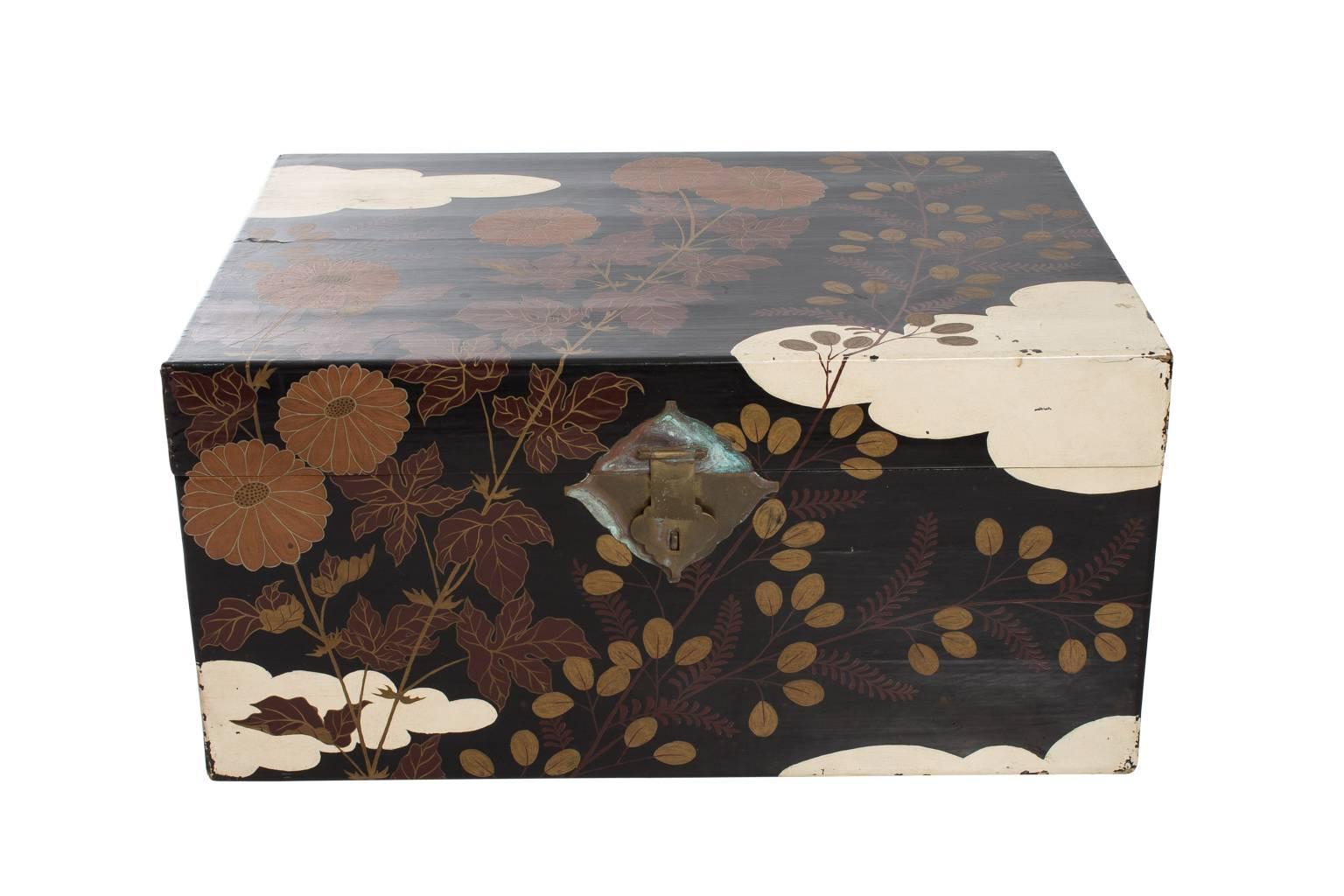 Pair of Japanese lacquered trunks hand-painted in traditional floral motif on ebonized background with original hardware, early 20th century.