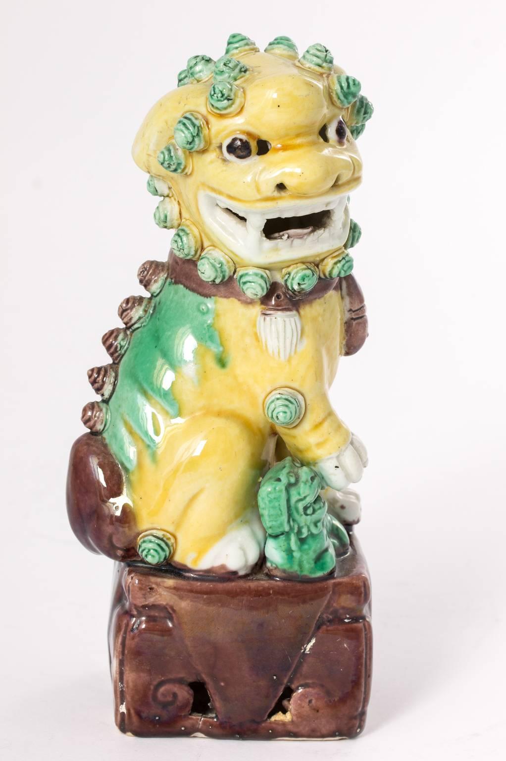 Pair of color-glazed, early 20th century, ceramic Chinese foo dogs.