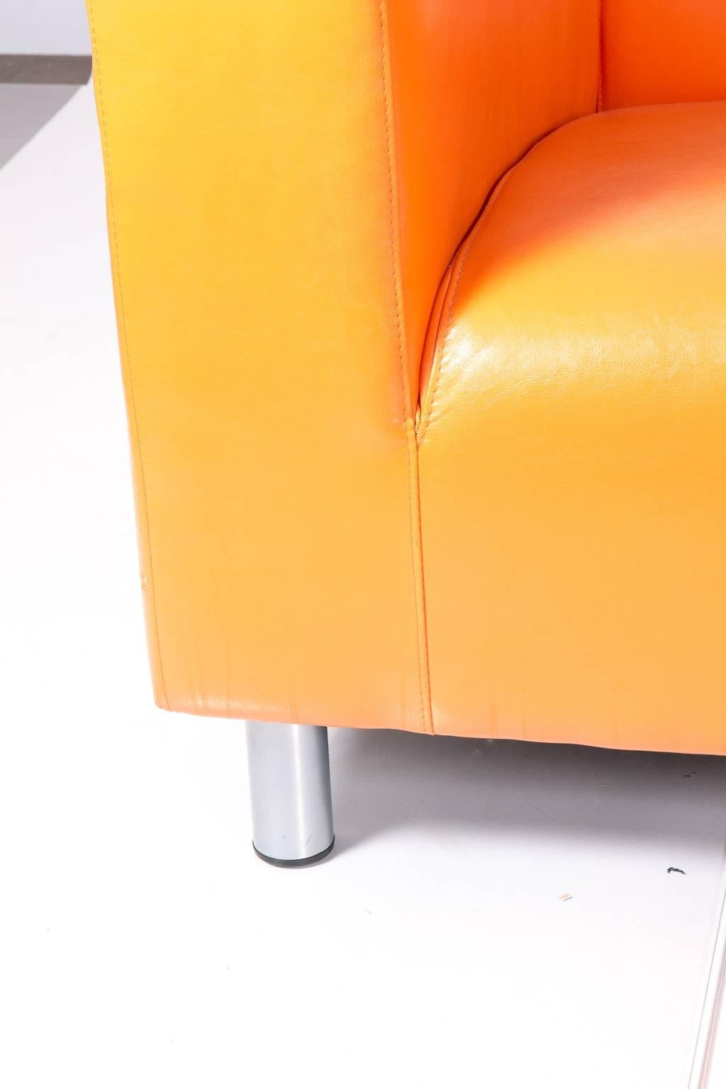 Shockingly orange vintage style sofa on metal legs.