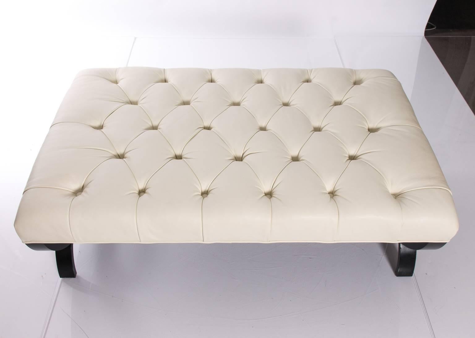Tufted white leather ottoman by Thomas Pheasant for Baker. Solid wood base. Several minor scratches on the base.