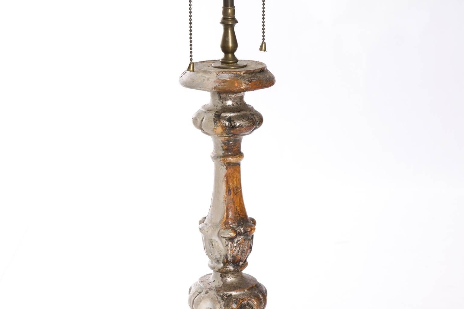Pair of 18th century Italian candlesticks which have been mounted as lamps. The candlesticks are Baroque in style and silver gilt.