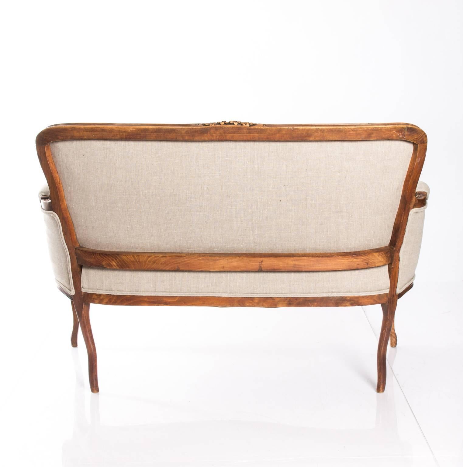 Early 20th century French walnut settee in Louis XVI style.
 