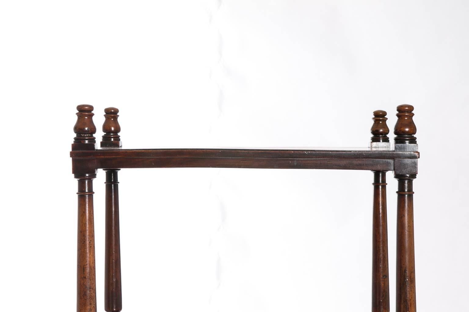 A 19th century English mahogany three-tier étagère on casters with ball-and-ring turnings.
 