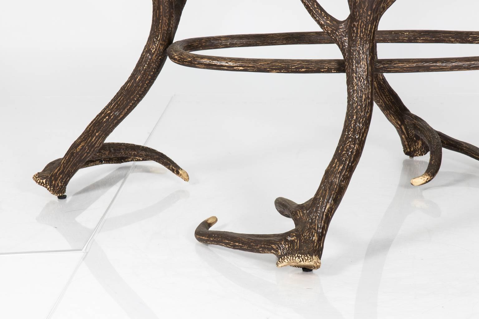 Faux deer antler table with textured metal base and glass top.
 