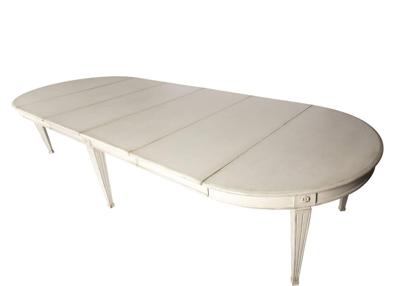 A large white painted Gustavian style dining table with four extra leafs. 
 
