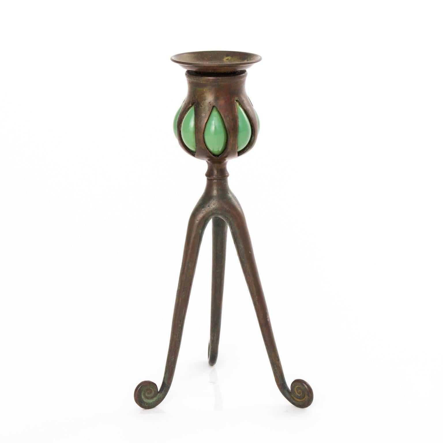 Tiffany Studio three-leg candleholder with green blown glass and curled feet, circa late 19th century.
 