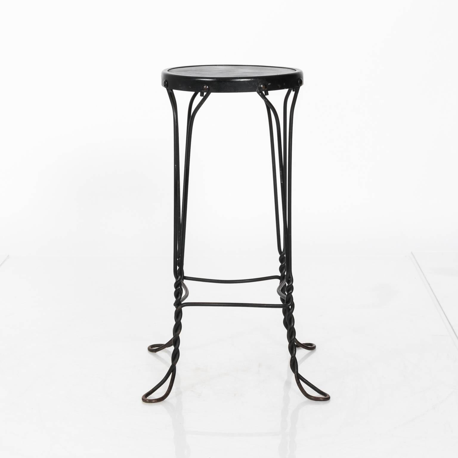 Pair of twisted wrought iron French bistro bar stools with wooden seating, circa 1950s.
    