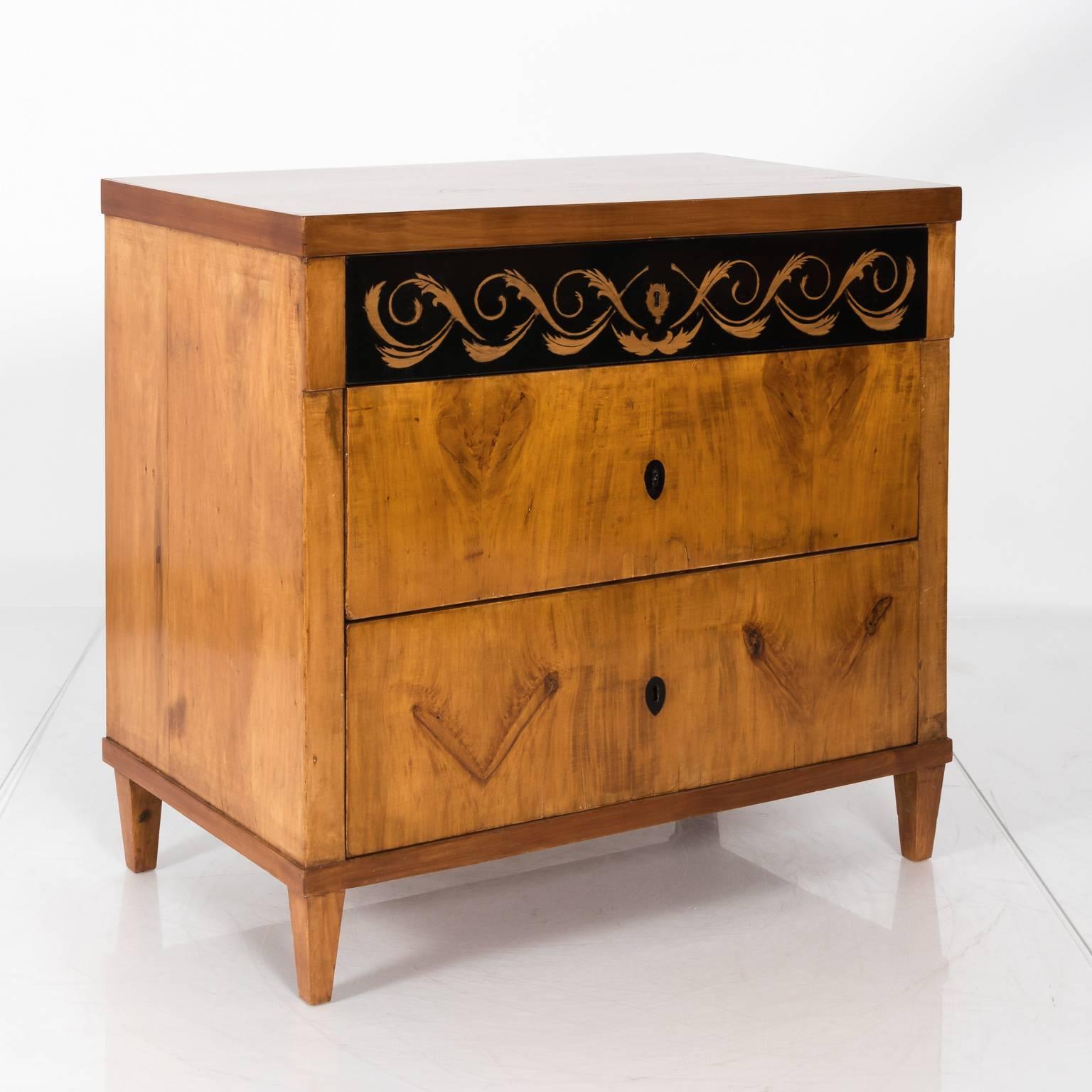 Circa 1820 Biedermeier three-drawer chest with inlay scroll marquetry.
