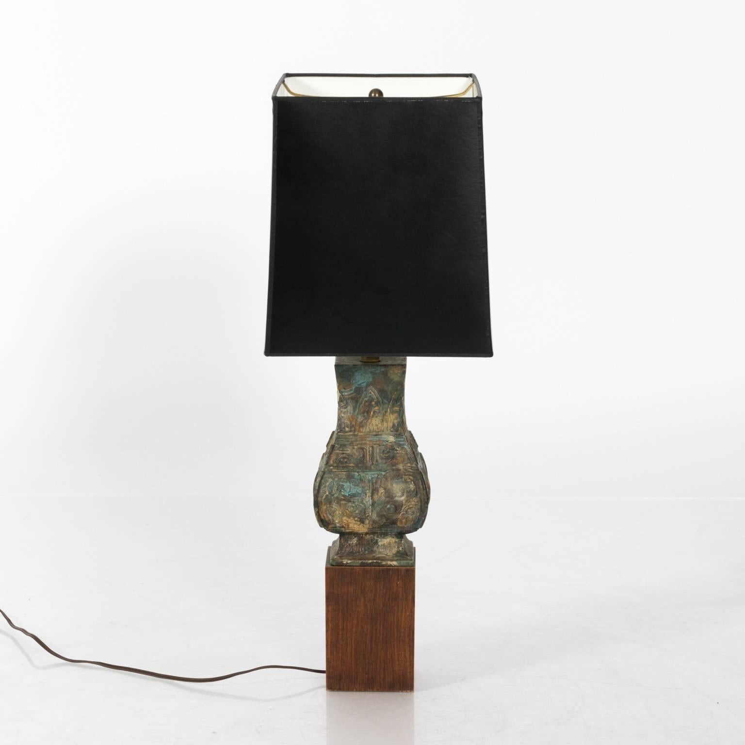 Chinoiserie style lamp of patinated metal on a wooden base, circa 1960. Shade included.
 