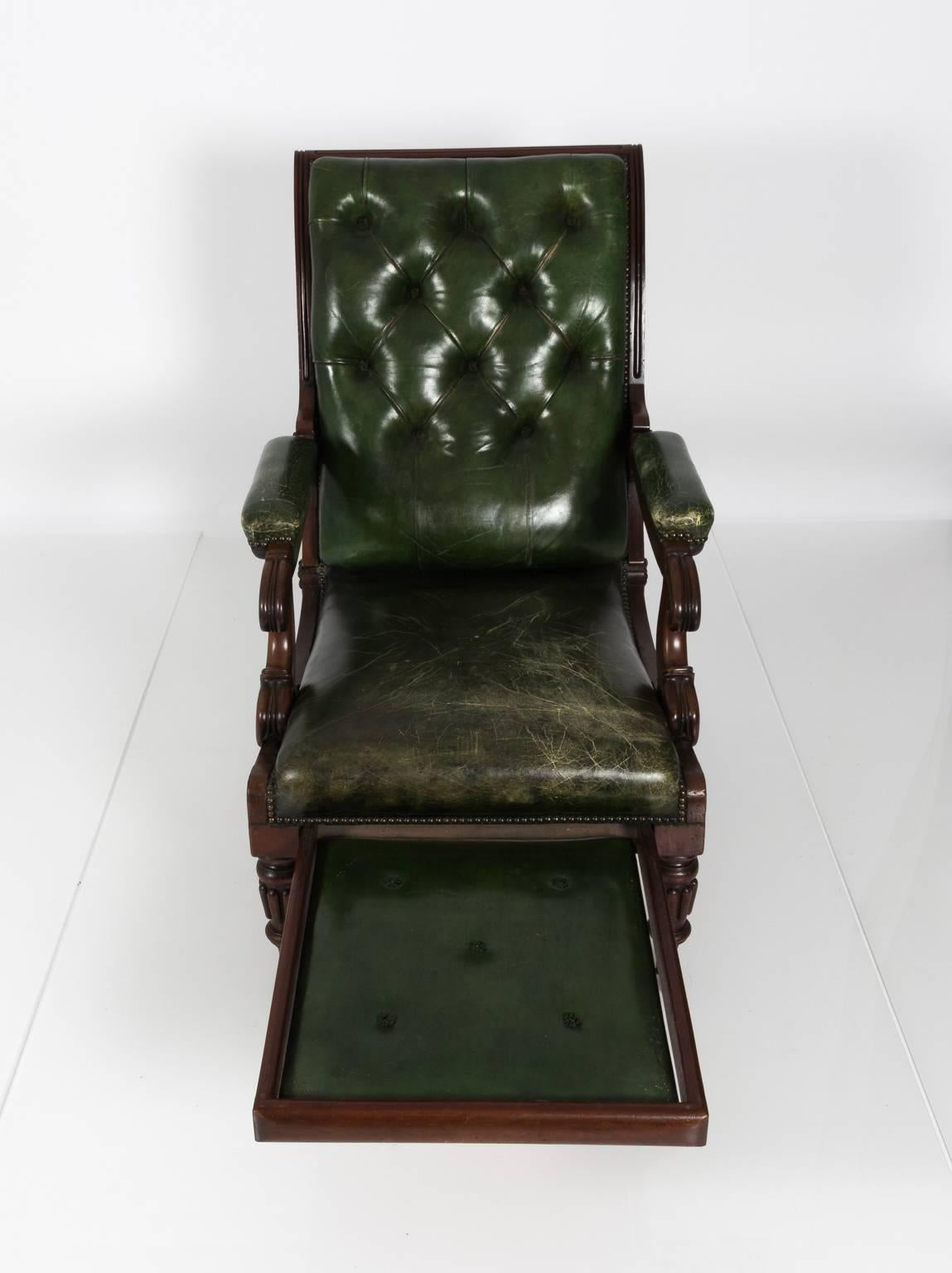 William IV style green leather chair that features a pull out reclining footrest, circa 1840.
 