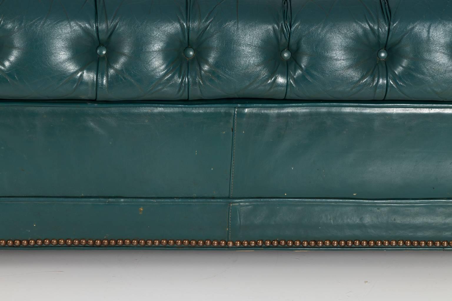 Circa 1970 three seat Chesterfield sofa in tufted green leather with bun feet that features a pull out mattress.