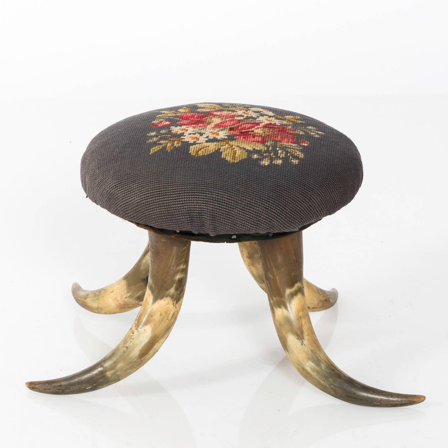 Antique horn footstool that features an upholstered needlepoint cushion, circa early 20th century.