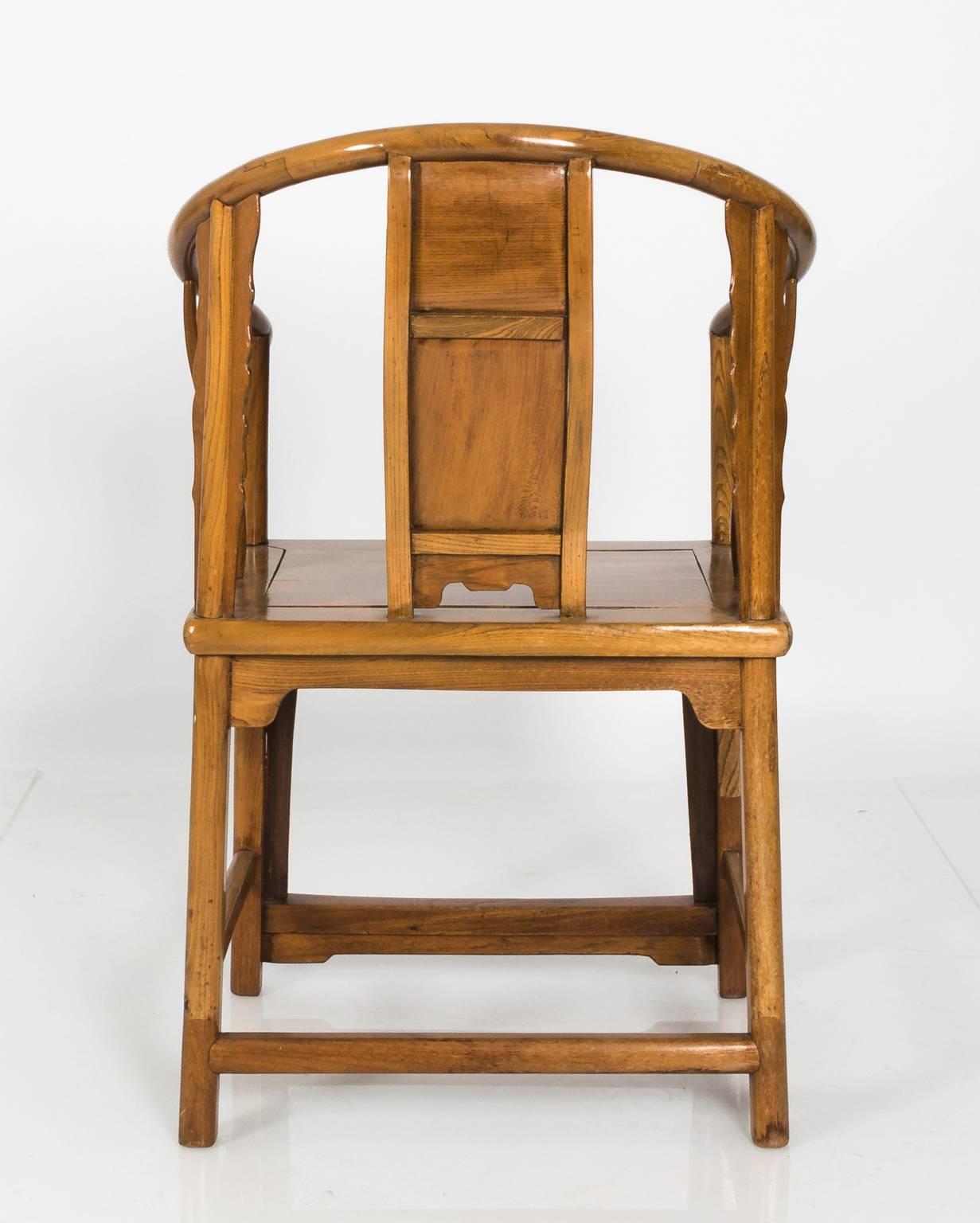Pair of Chinese slat back armchairs in Elmwood that feature Lao Tsu carvings on the back, circa late 19th century.