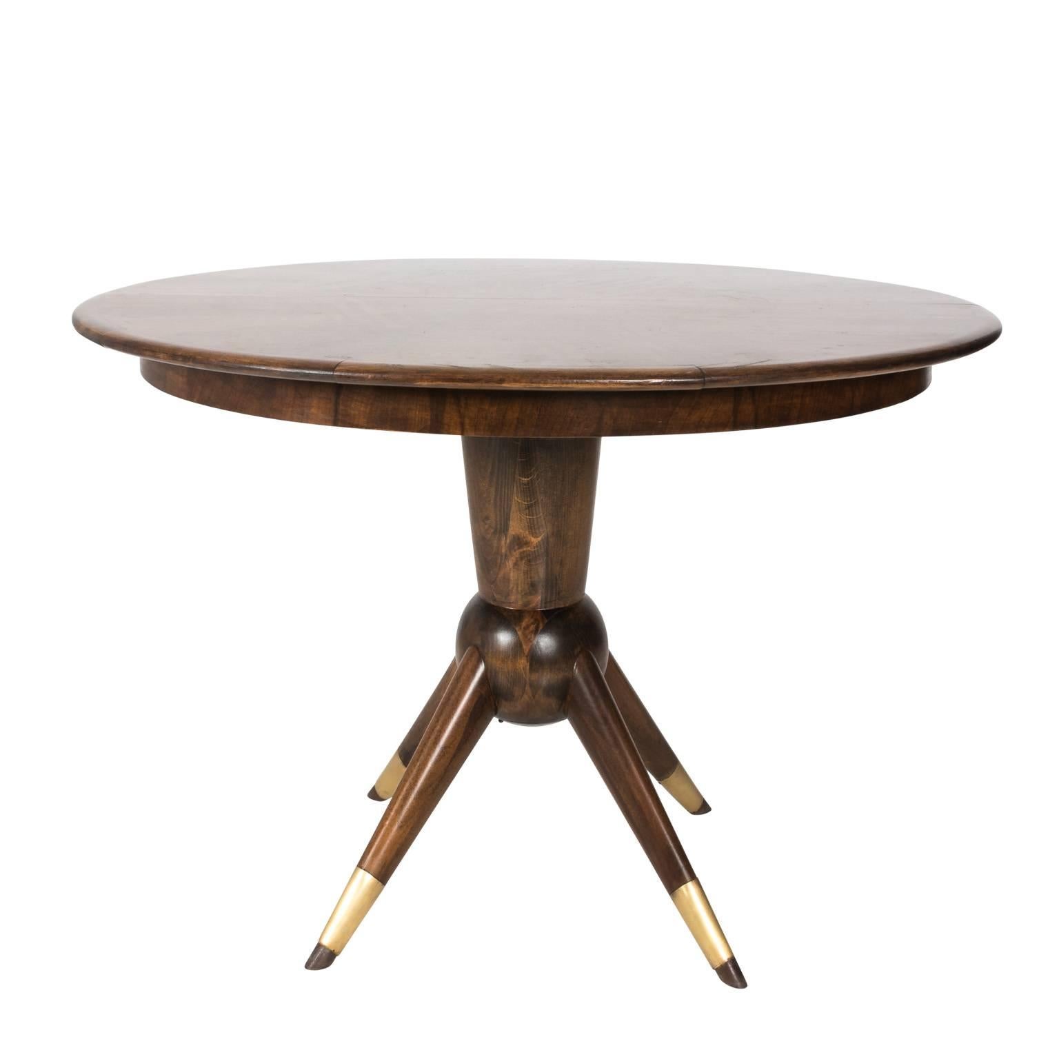 Mid-Century Modern teak wood adjustable oval/round dinging table on four legged pedestal with brass bands. This table folds to a round pedestal table that measures 46