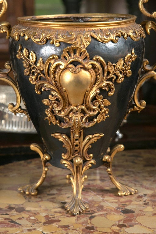 applied gilt bronze decorative mounts of scolls, leaves,  shell , flowers in the rococo manner.  patinated  bronze body.  dimensions of width and height include handles