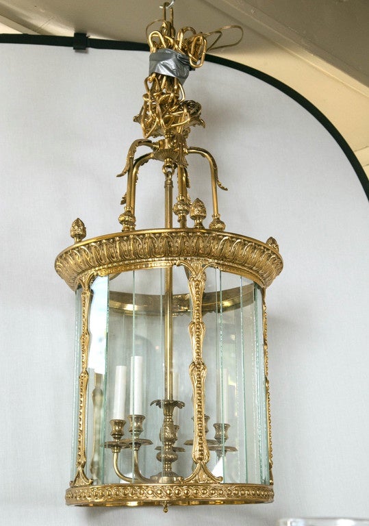 Dating from the 20th century, this lantern is unusually constructed. The glass panes all fit into a hidden groove at the top and bottom. The panes are not attached, so they do move. Each pane of glass is approximately 2 x 15 inches. Acorn finials