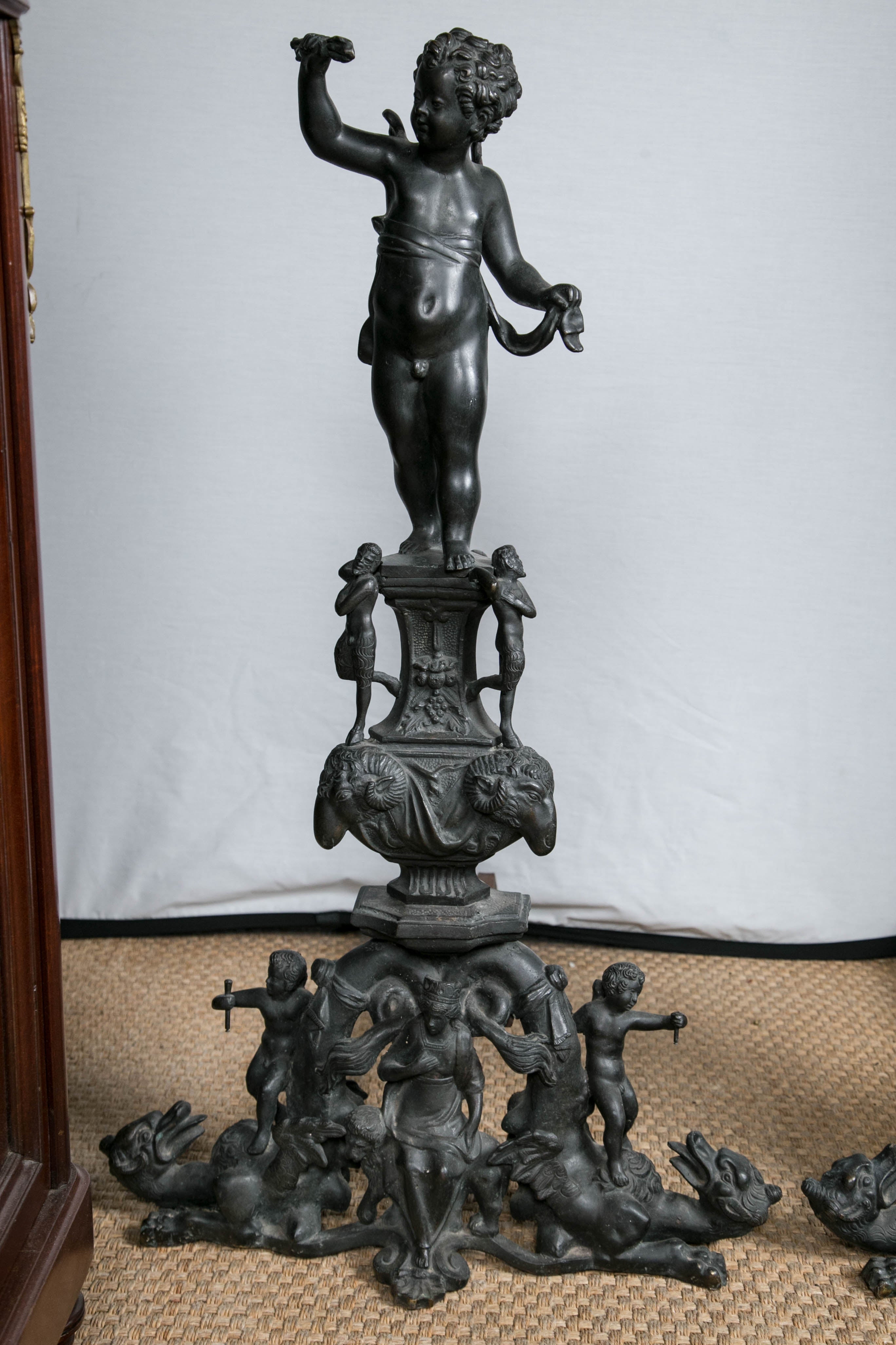 This pair is topped with winged putti above an urn decorated with satyrs standing a top ram's heads. Below are more winged putti with dragons.