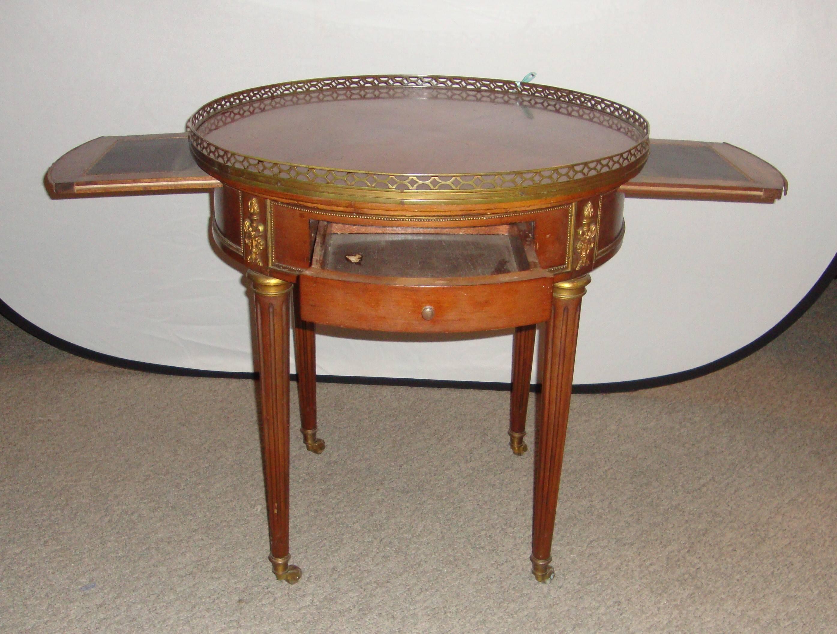 A French Louis XVI style mahogany Bouillotte table manner of Maison Jansen, with brass gallery. Having two pull our drawers and two pull-out extensions. Each pull-out extension measures 9 inches each.