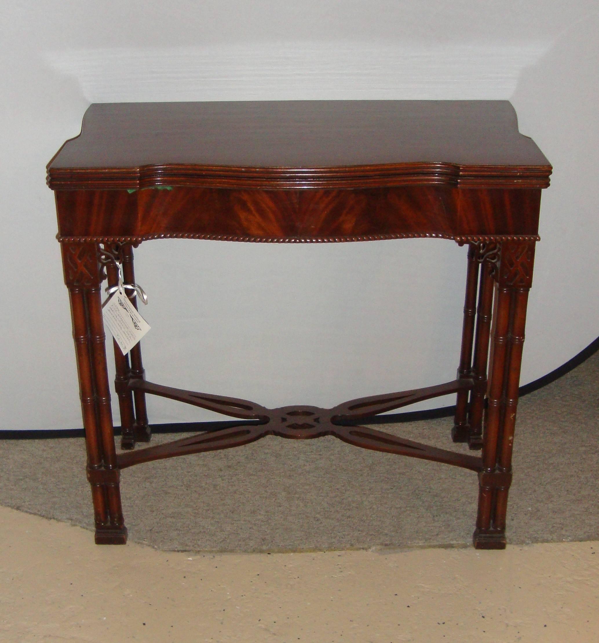 A fine Chippendale mahogany serving-card table, sitting on bamboo shaped legs. A flip-top crotch or flame mahogany card or serving table, circa 1940s. The straight form legs being supported by a carved under carriage make this table structurally