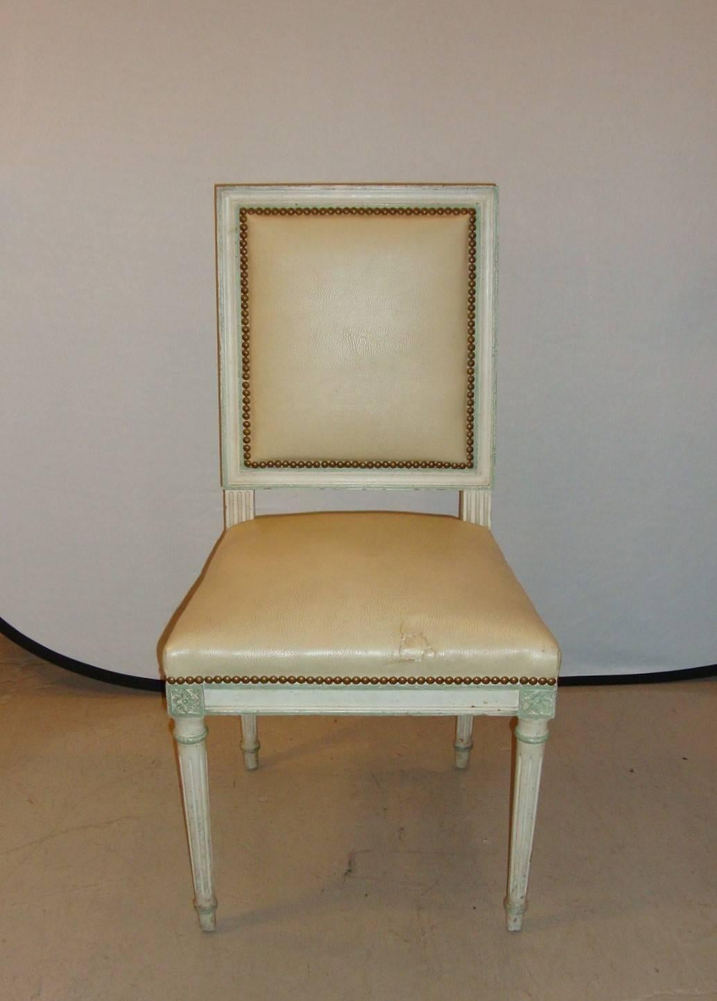 A Louis XVI style side chair by Maison Jansen, the chair has studded lining throughout in a distressed cream paint color.