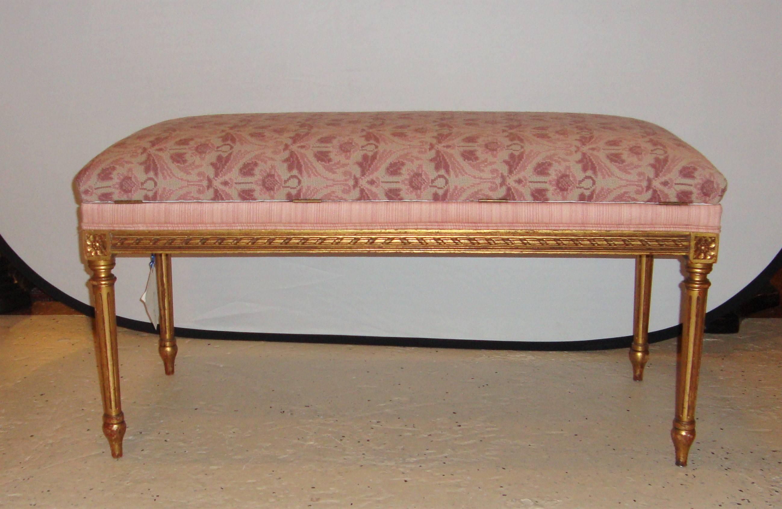 Gilt piano bench with fluted legs and carved florets. Cushion with pink, rose patterned tapestry fabric.
