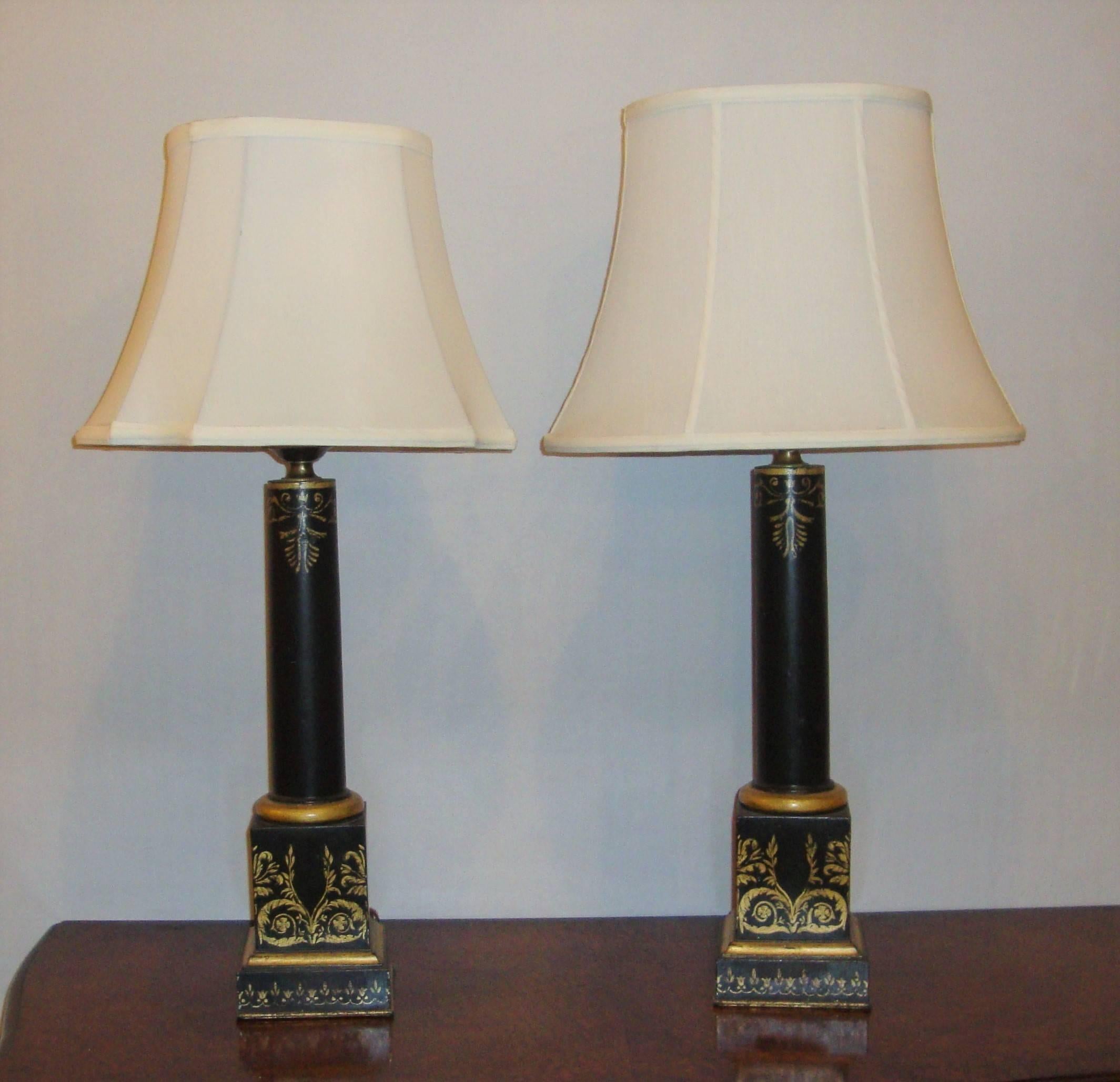 A pair of ebonized lamps in a column style of tole design. Gilded, elegant, floral design on all four sides of square base.
Shades not included.
    