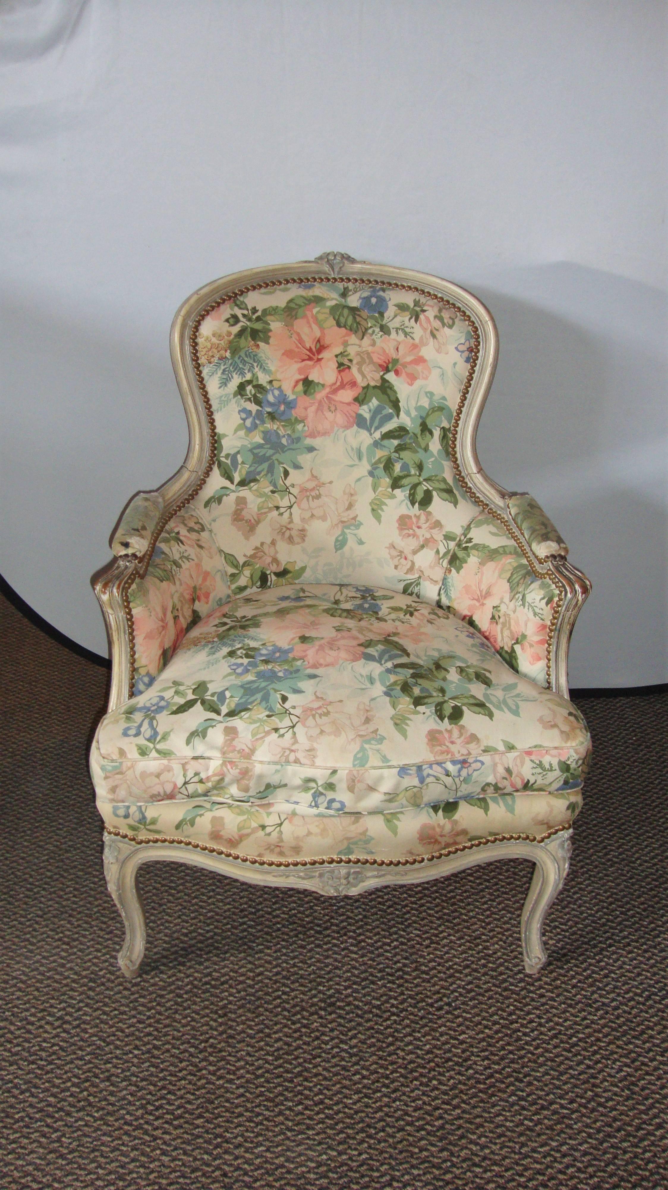 Pair of Louis XV style distressed paint decorated chairs by Jansen. Highly desirable pair of arm lounge chairs in the Hollywood Regency Era. The curved legs terminate in a carved rose and leading to curved arms and a backrest also terminating in a