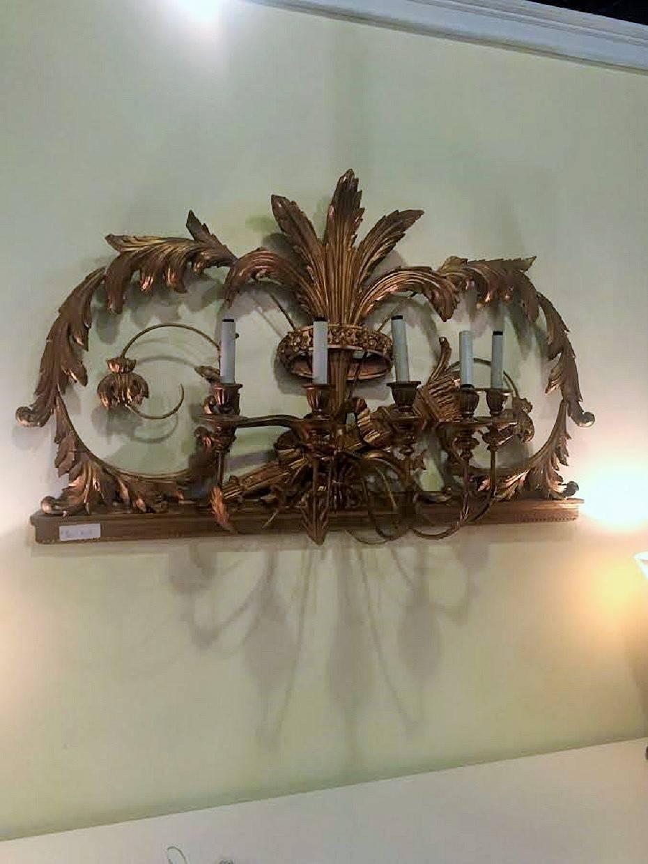 Italian five-light gilt gesso wall sconce. This five light heavily carved wall sconce has flowing arms set upon a carved leaf and rose with vine designed frame.