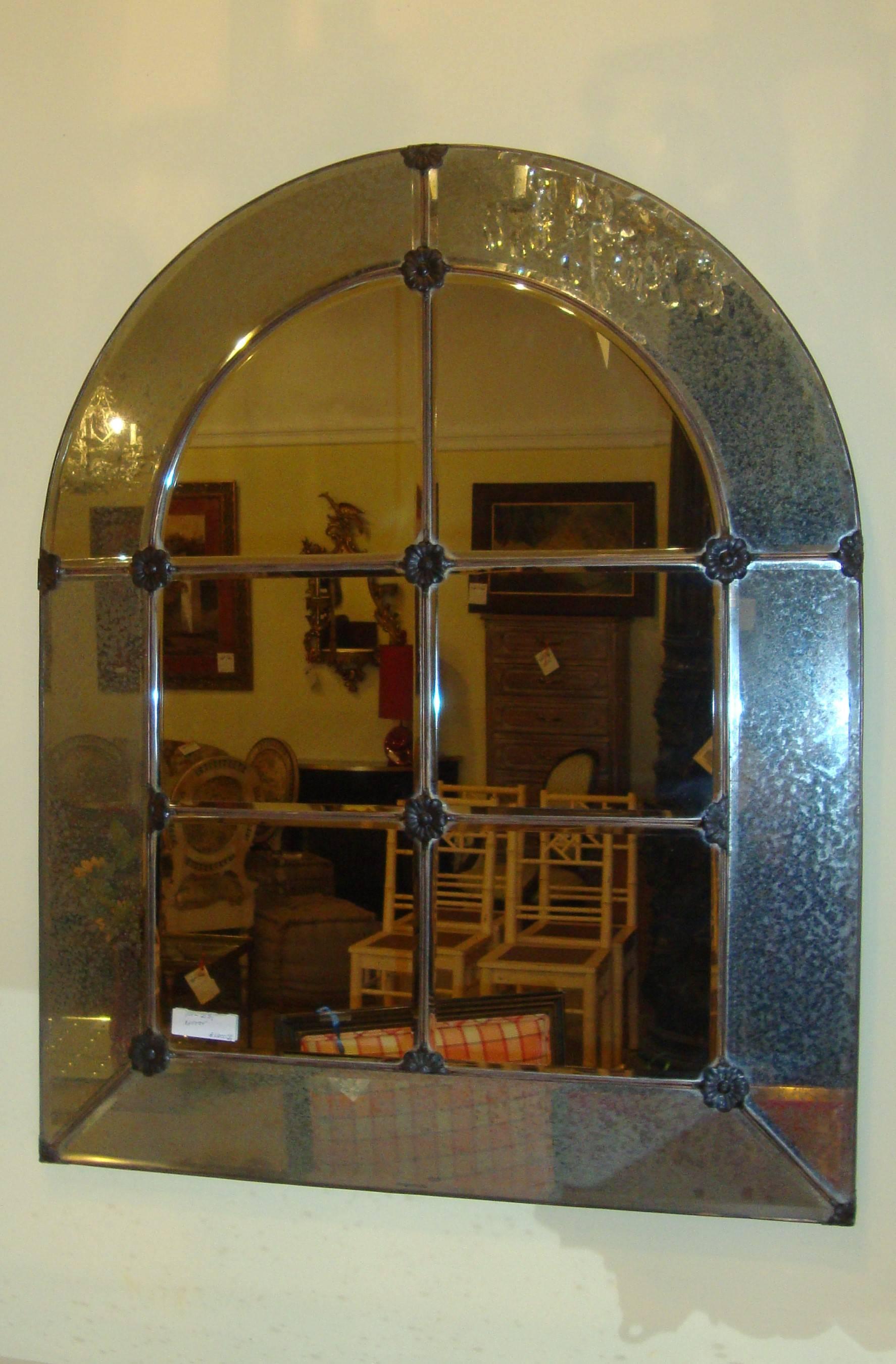 A Hollywood Regency style wall or console mirror. The clean center having six panels framed by a distressed outer border with rosettes.
