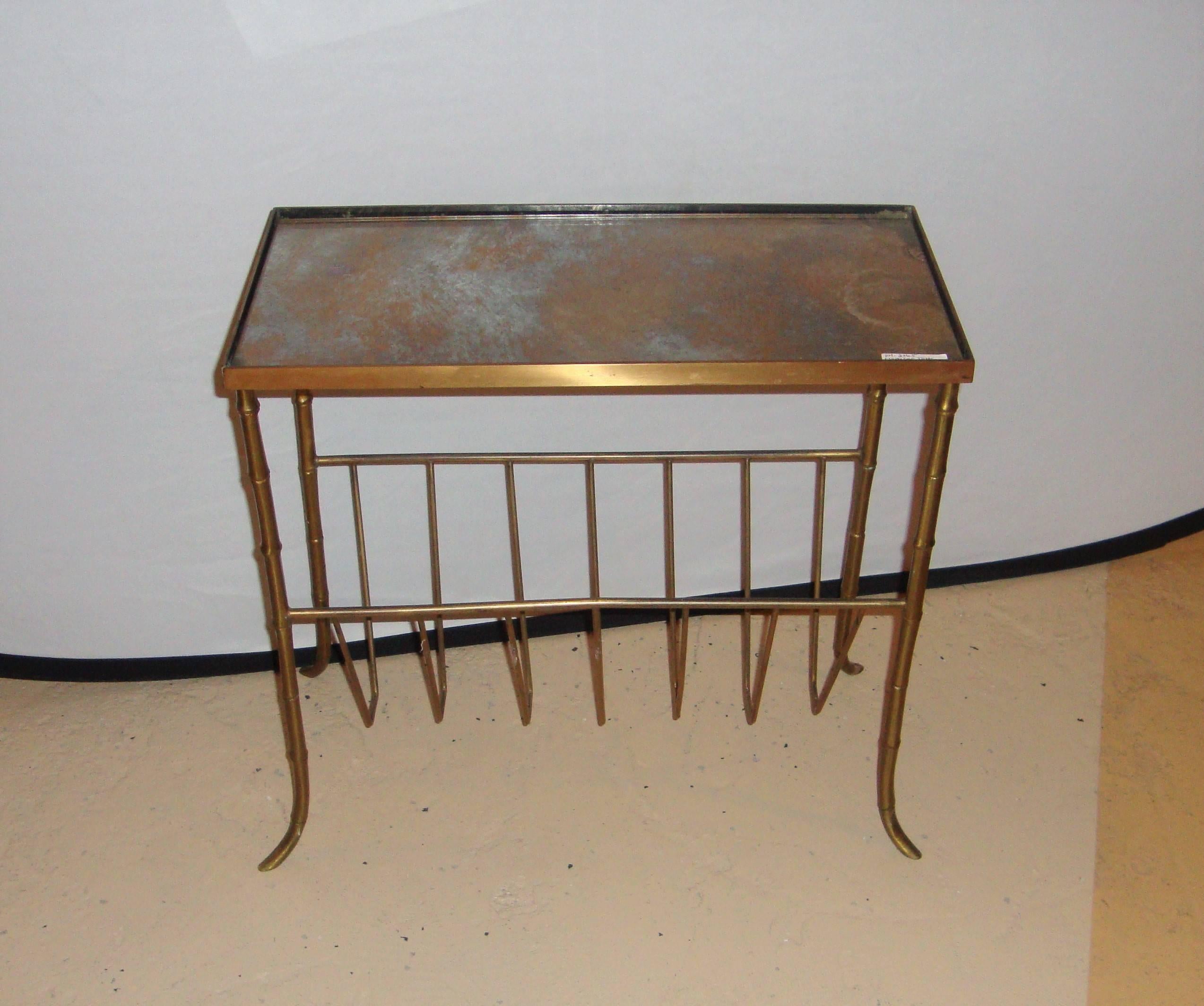 An elegant Bagues style bronze bamboo form magazine table. Bronze with distressed gold gilt glass top, sitting on bamboo form legs.