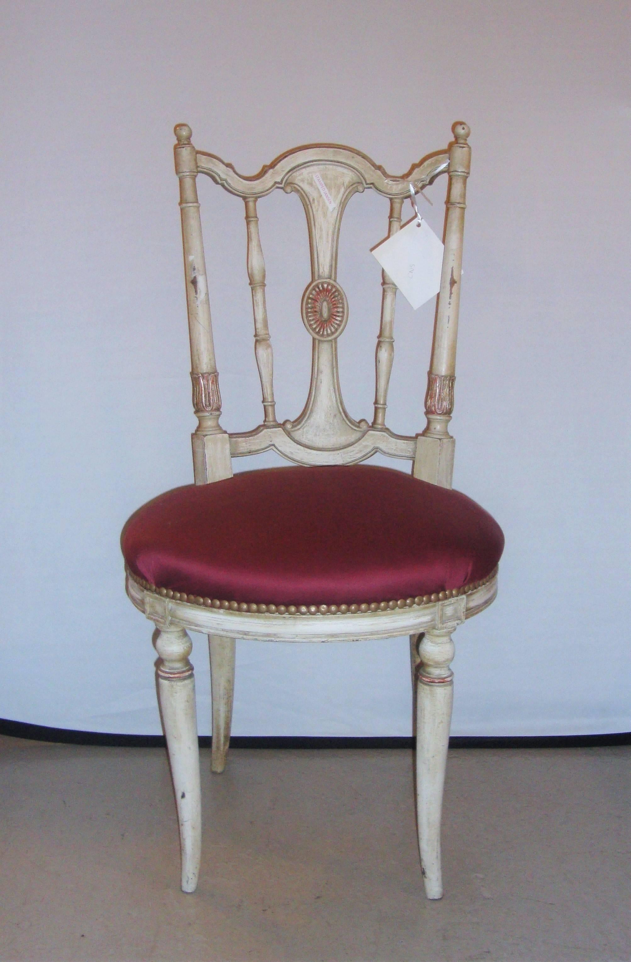 Distress painted lady’s side or desk chair. This circa 1930s side chair has been finely painted in a distressed finish with worn gilt over clay. The shield back supported by an overstuffed seat and curved lets.