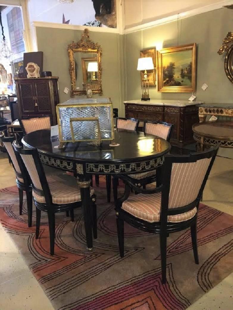 Set of six Hollywood Regency style dining chairs manner of Maison Jansen. Ebonized and with bronze mounts these recently done over chairs depict the Hollywood Regency era wonderfully and are fine examples or the work of this leading designer. The