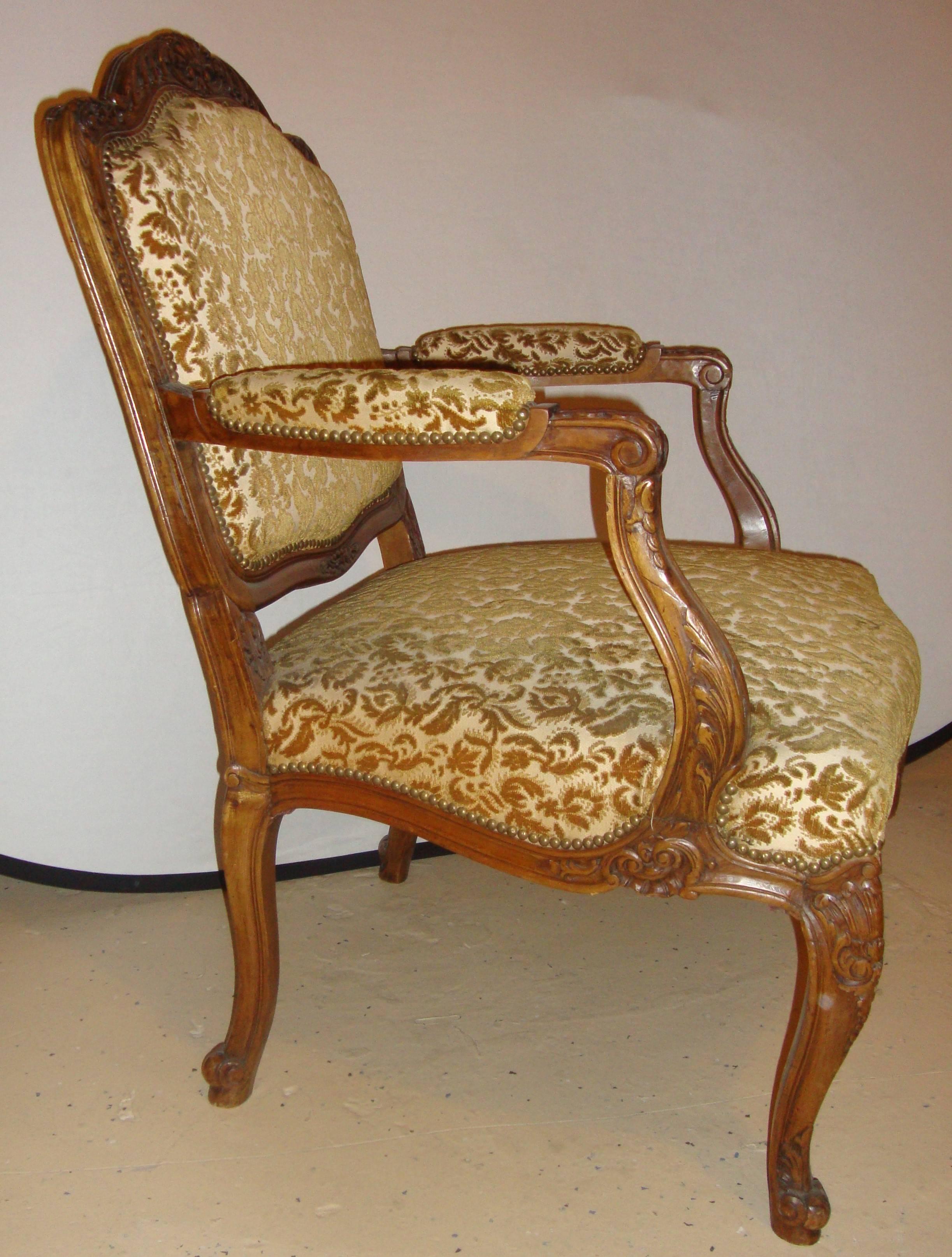 Ein Paar Rokoko-Sessel im Stil von Louis XV mit Schnitzereien. Jeder der massiven und studierten Bergere-Stühle ist im Stil von Louis XV mit Schnitzereien in Form von Schnecken und Muscheln auf einem Nussbaumgestell gestaltet.