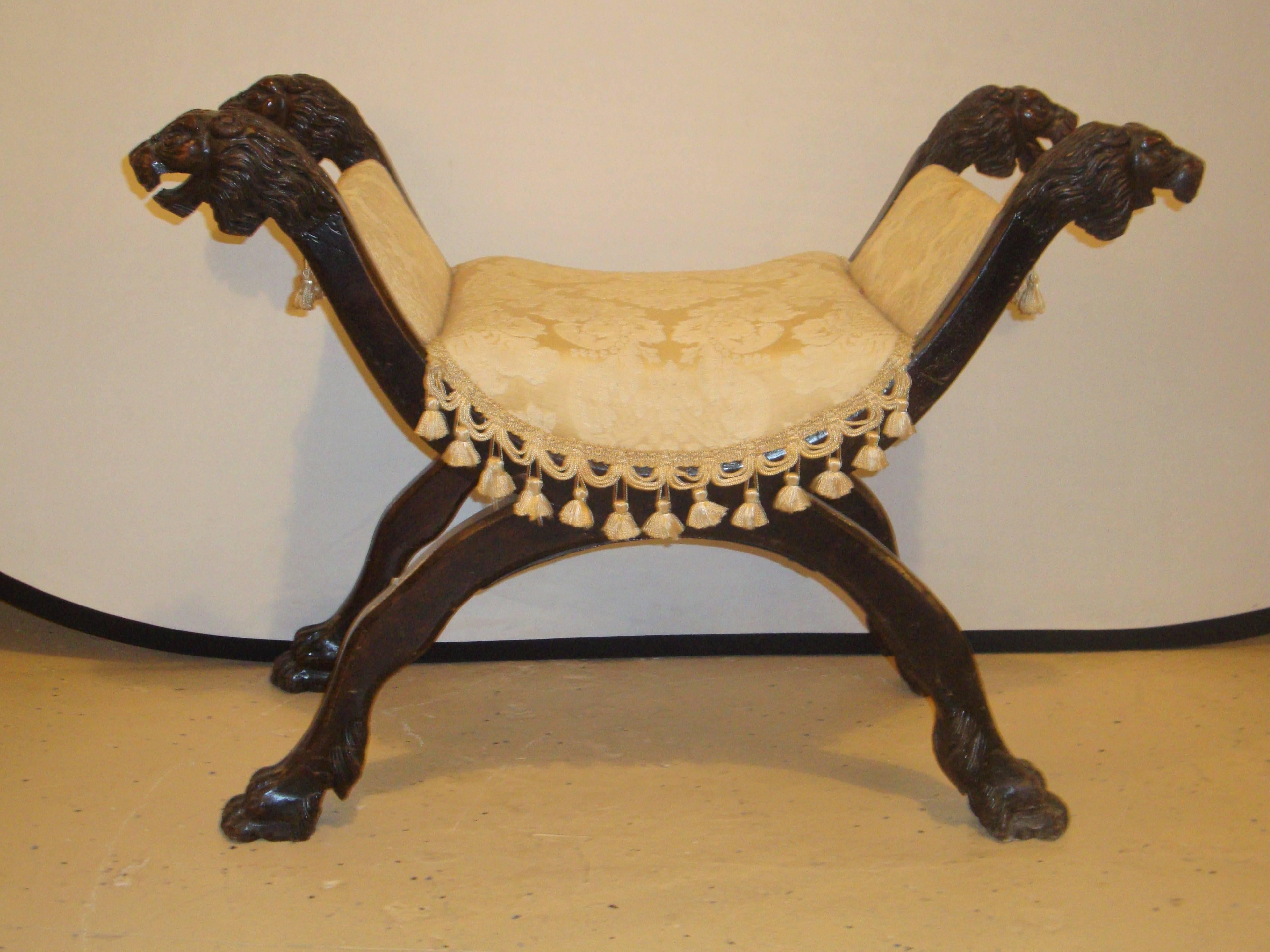 19th century lion head X bench. A finely carved and detailed bench in the X-form with carved lion heads.