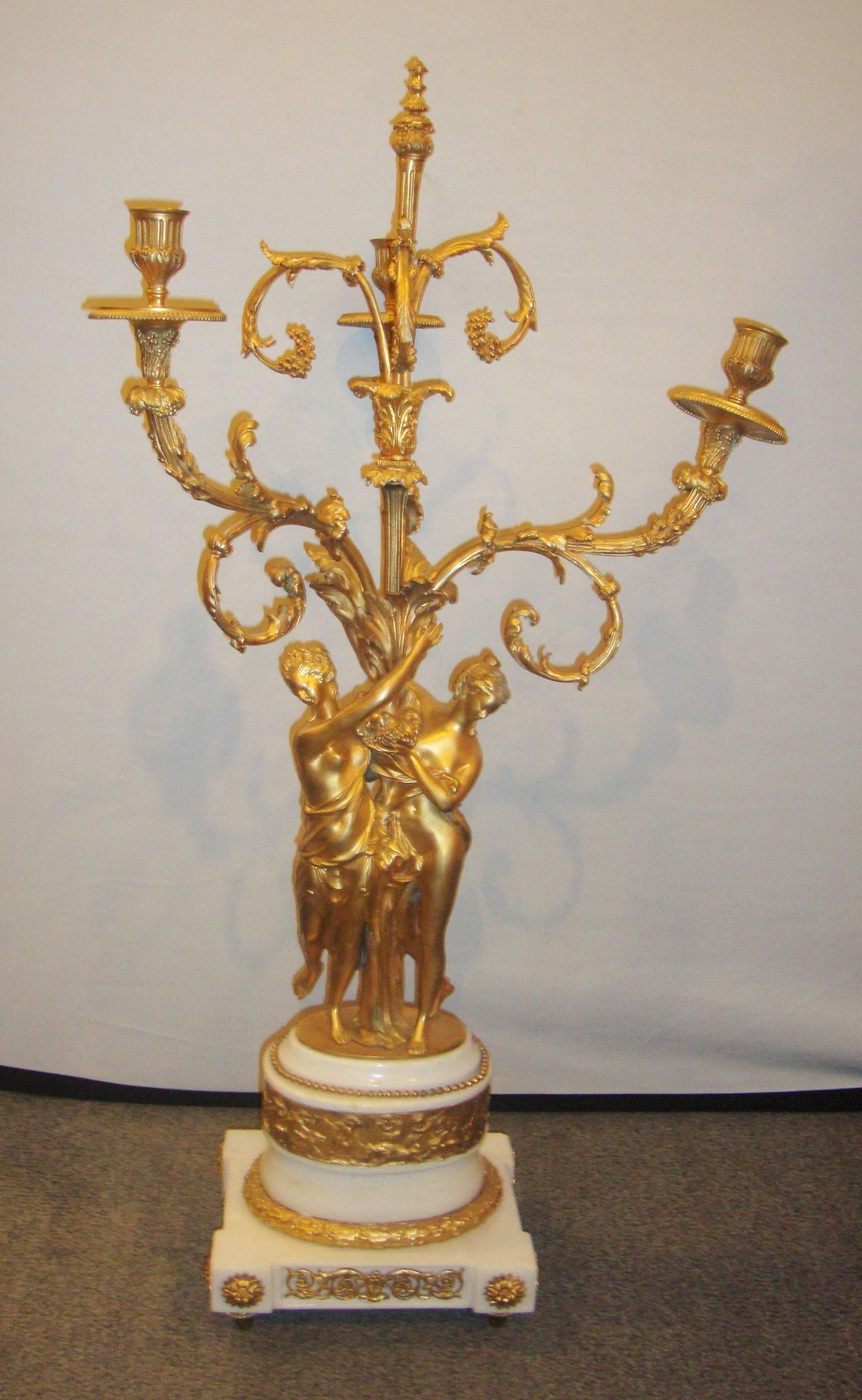 Pair of figural bronze candelabras on marble bases. Each having a pair of neoclassical full bodied woman holding up a candelabra.