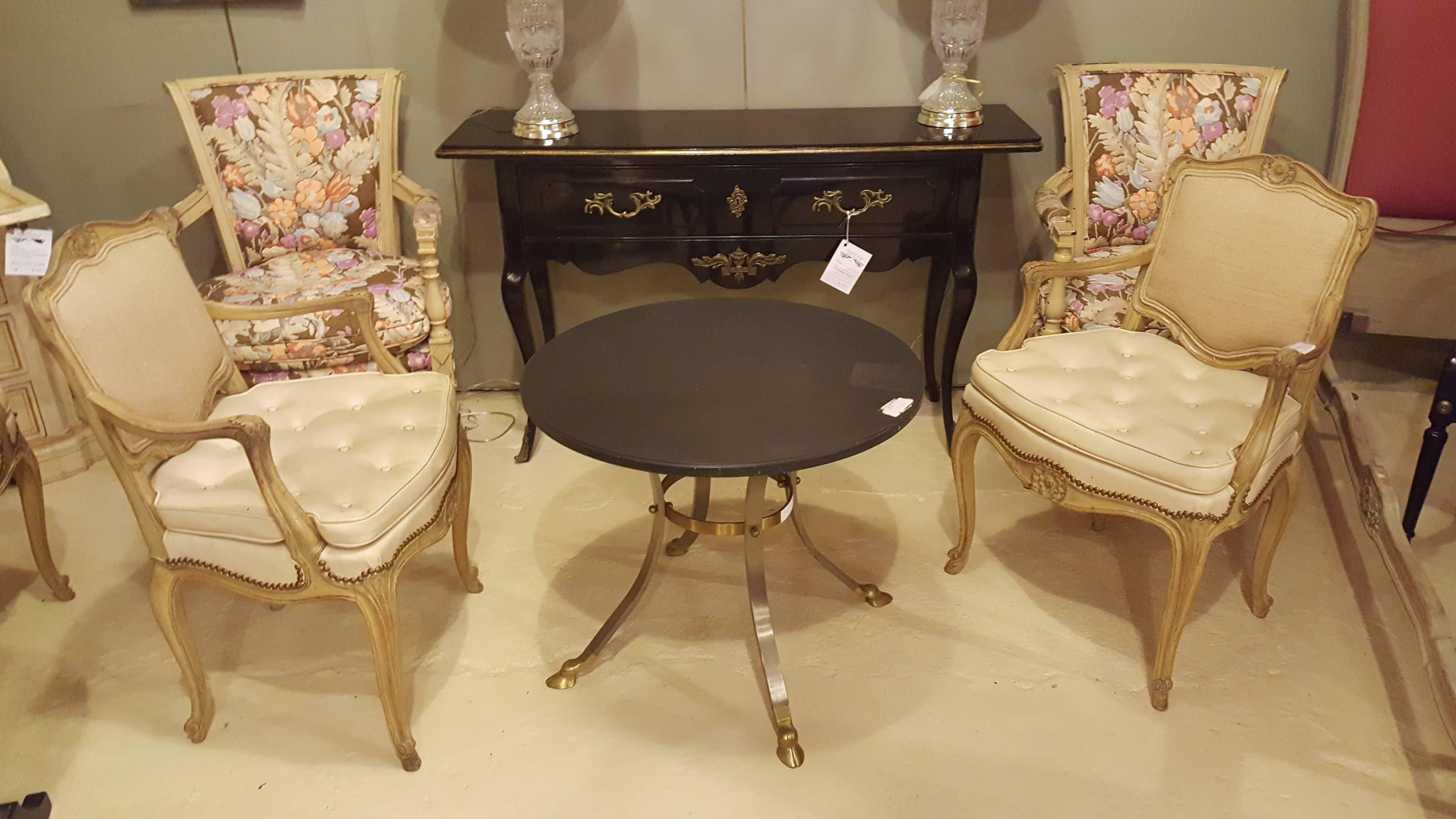 A brass and steel Gueridon table attributed to Maison Jansen. This unique table has an ebony circle marble top, and sits on four hoofs stylized feet.