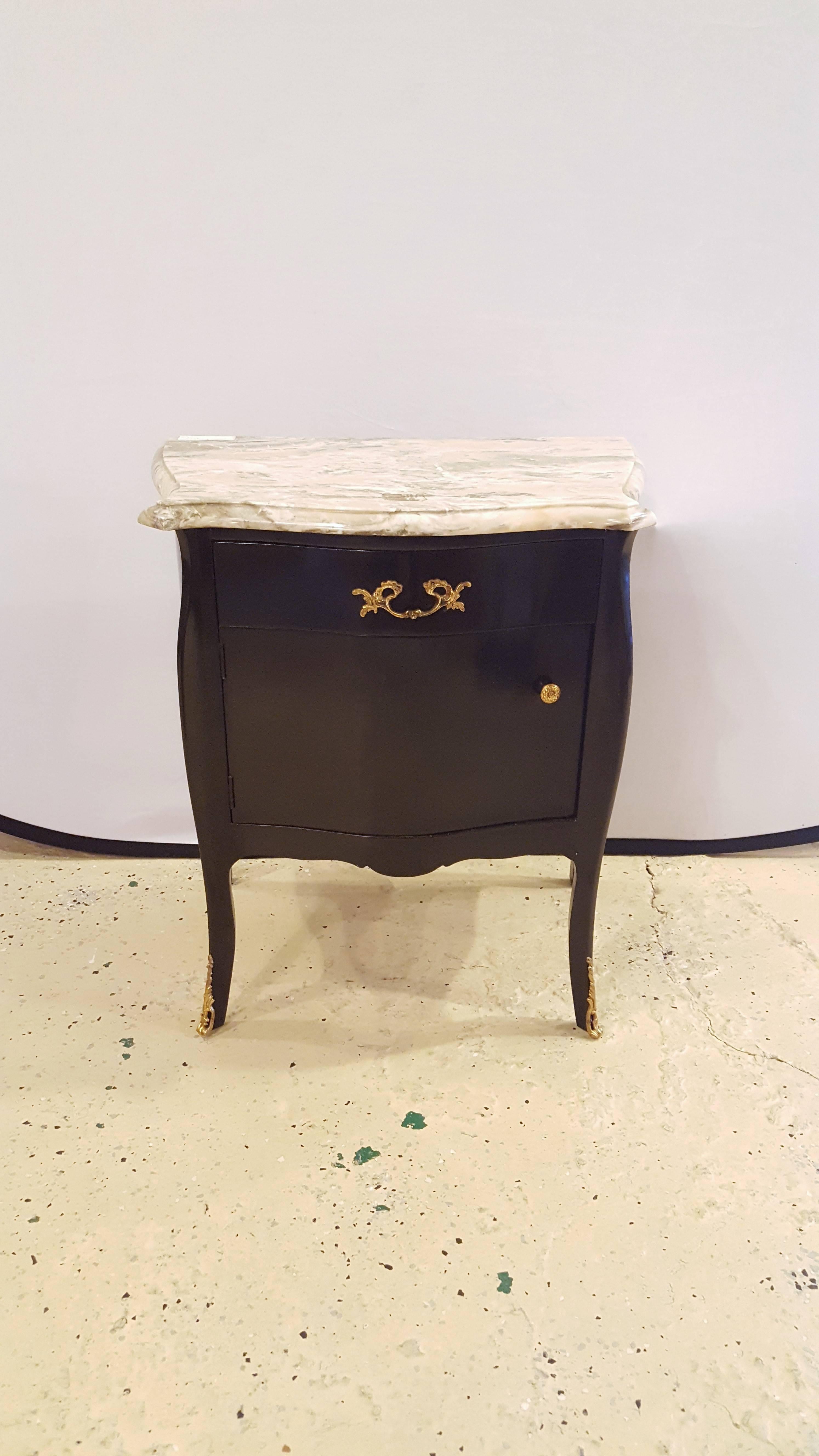 An elegant, sleek, pair of ebonized marble-top nightstands. Each piece has a single drawer, with a single cabinet below, they also have marble top and bronze mounts. The pair can be used as nightstands or side tables, would look beautiful in any