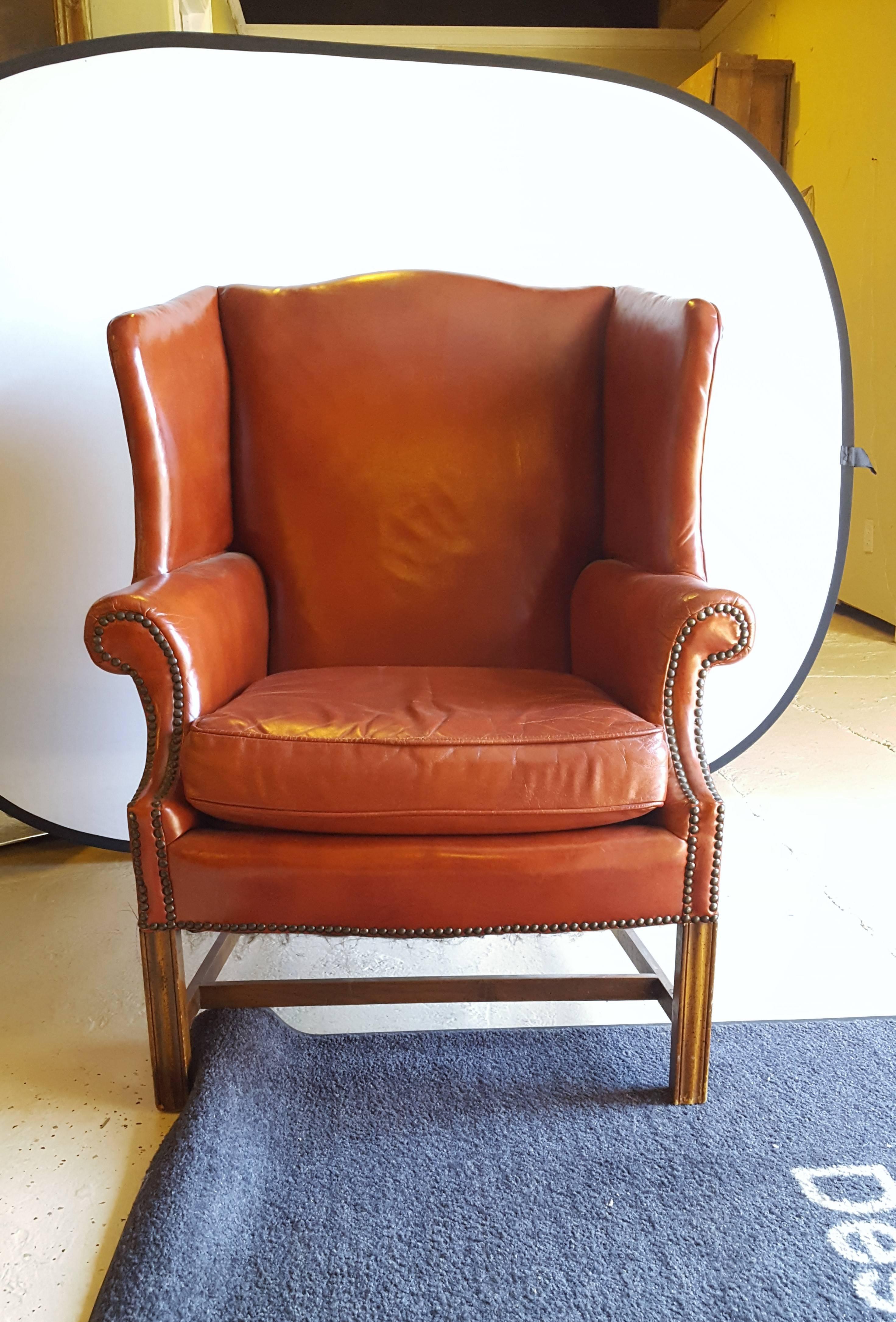 A Stately Traditional English Red Leather Wing Back Armchair With Nailhead Trim. Very comfortable large piece.