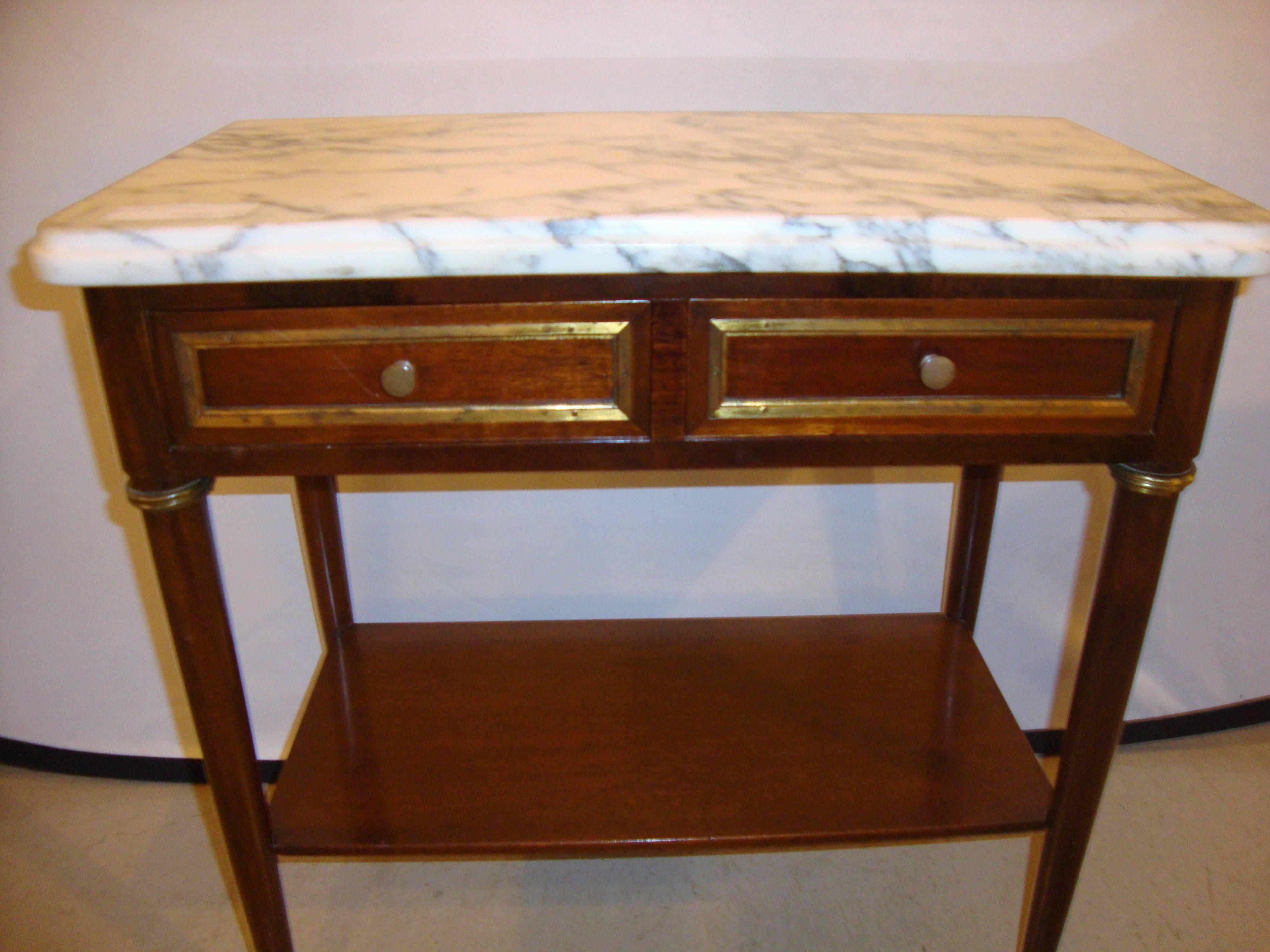 Diminutive marble-top mahogany stand, end table in the manner of Jansen. Louis XVI style case having bronze mounts double drawers supporting a marble top.