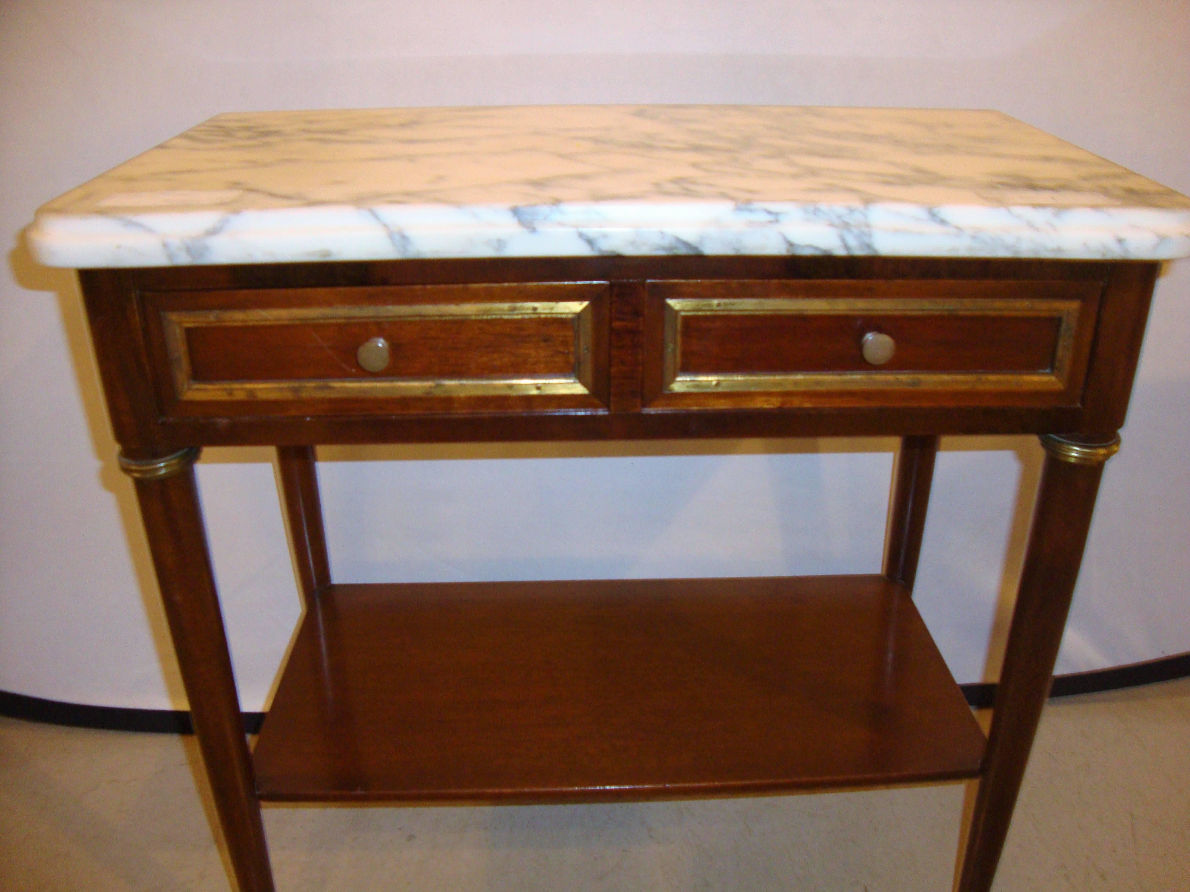 Diminutif stand en acajou à plateau en marbre, table d'appoint à la manière de Jansen. Coffret de style Louis XVI présentant des montures en bronze et des tiroirs doubles supportant un plateau en marbre.