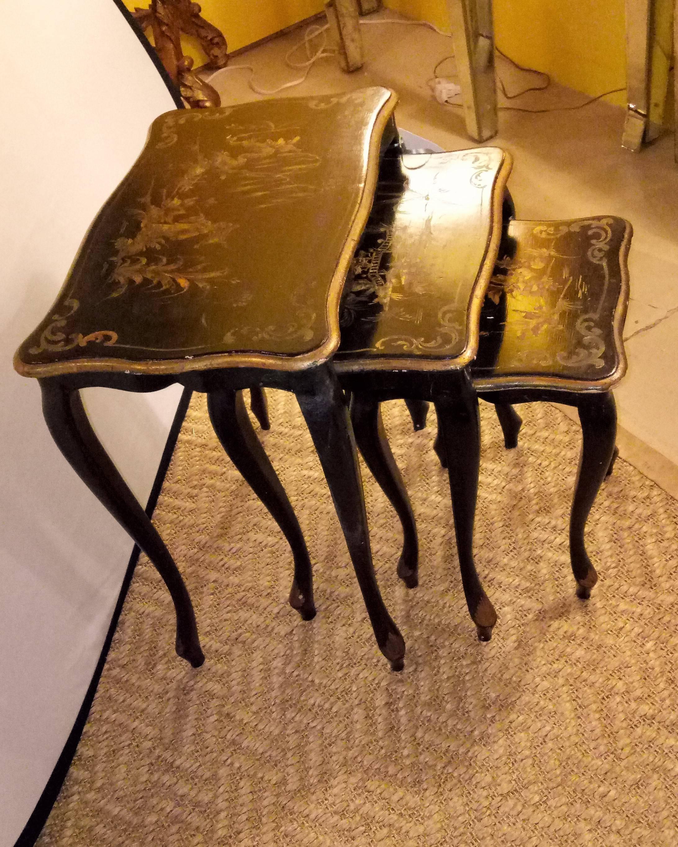 Set of ebonized chinoiserie decorated stack or nesting tables. Each having a Louis XV styled leg leading to a chinoiserie painted tabletop. 

Measures: Small: Height 17 inches, length 12.5 inches, width 12.5 inches
Medium: Height 19.5 inches,