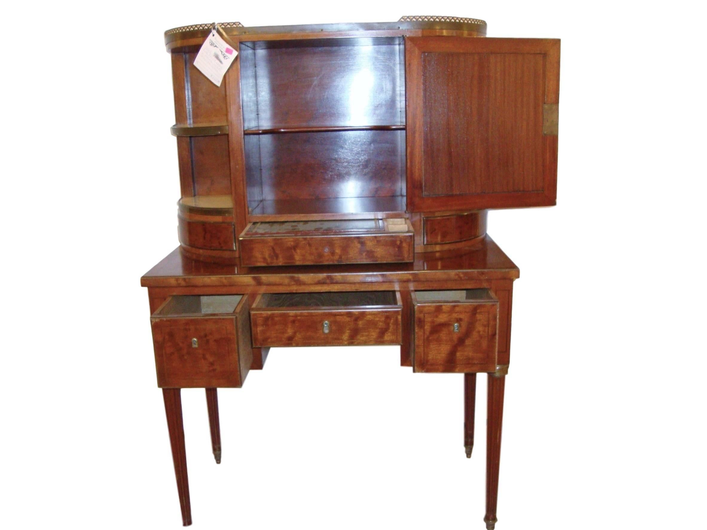 A Louis XVI style desk with vitrine Top. This fine custom quality Louis XVI style desk has long tapering bronze-mounted legs supporting a center drawer flanked by larger drawers leading to a set of three smaller drawers under a vitrine mirrored